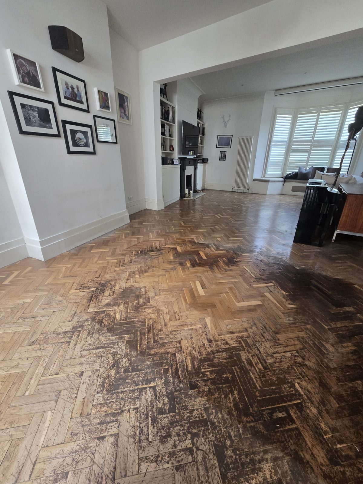 Tired original herringbone parquet before restoration, worn finish and dulled blocks