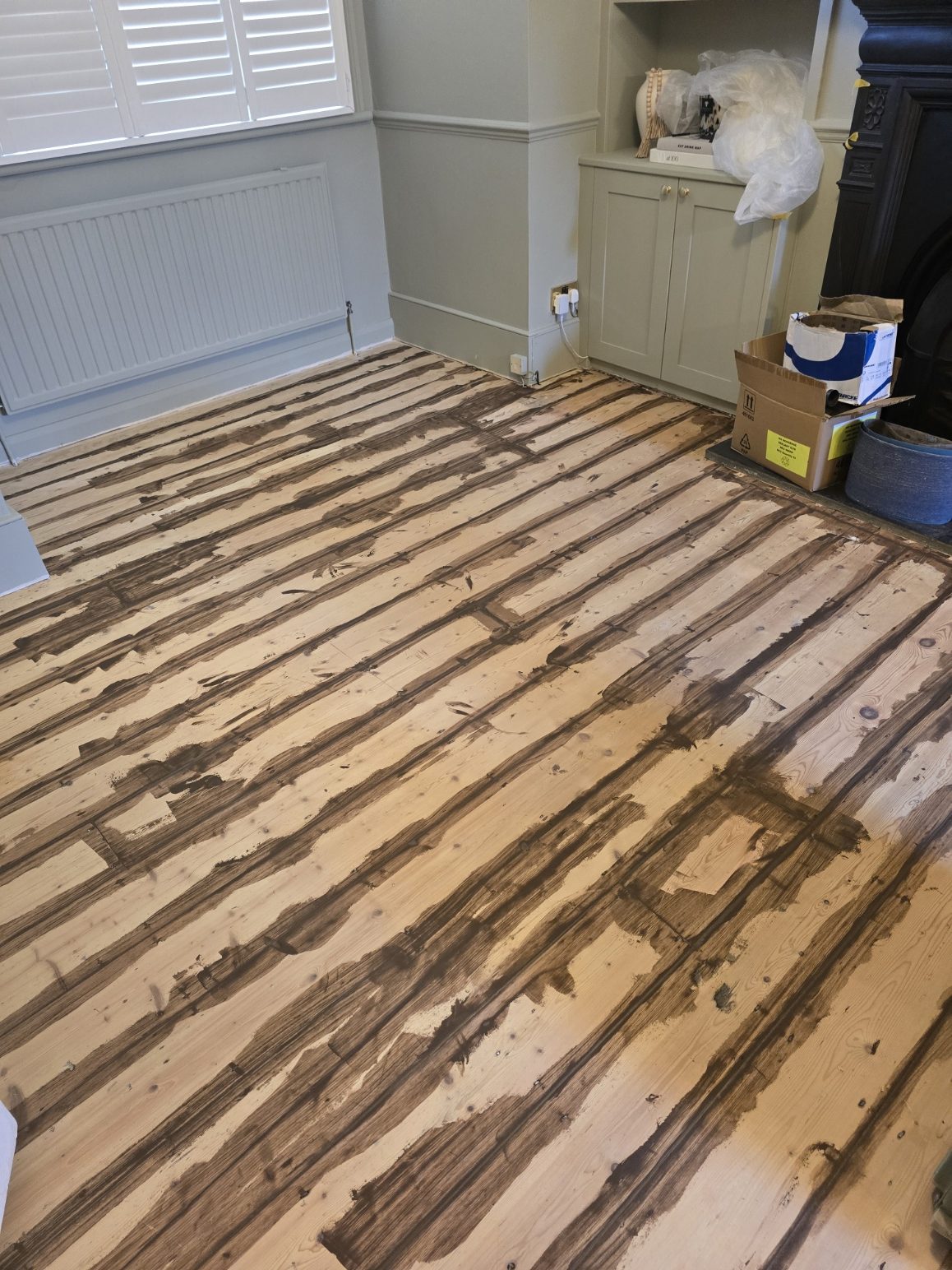 Original pine floorboards mid-job with flexible filler freshly applied along every gap