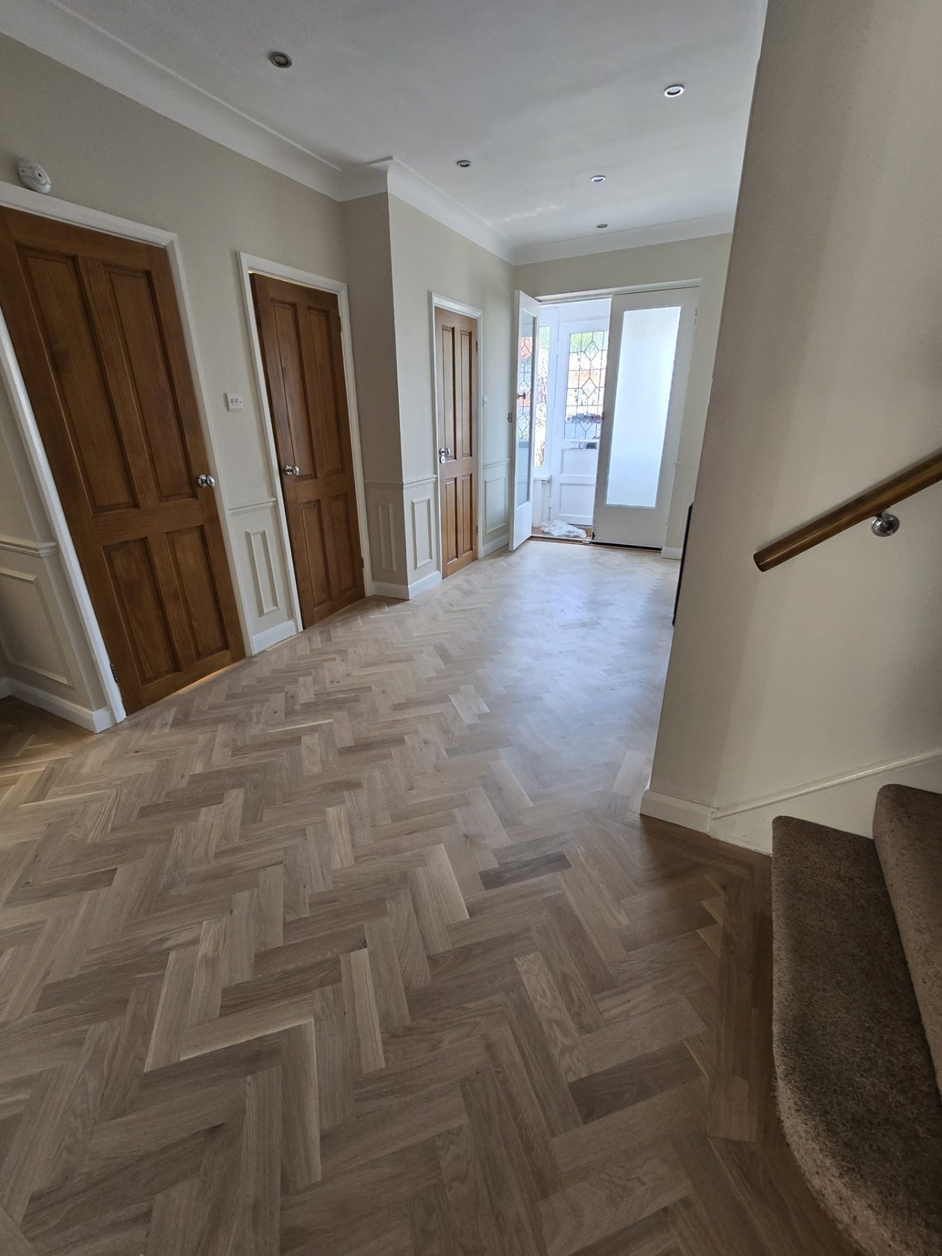 Oak herringbone parquet fitted through a 1930s Purley hallway with stained glass front door and original oak doors