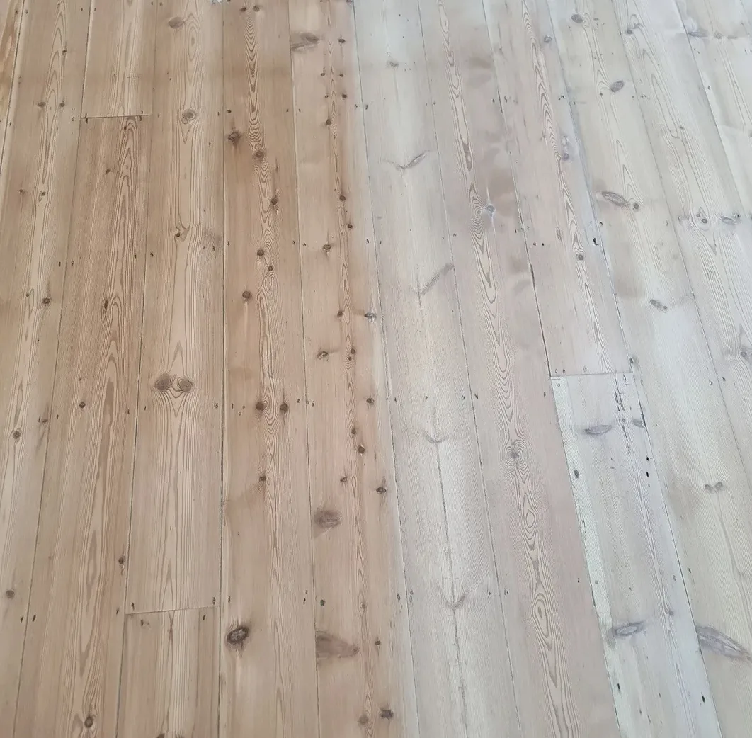 Pine floor mid-finish with orange boards on one side and light, white-finished boards on the other